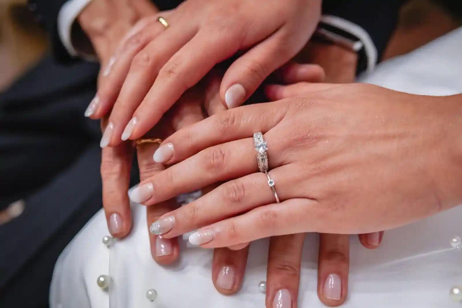 Primer plano de las manos de los novios con las argollas de matrimonio.
