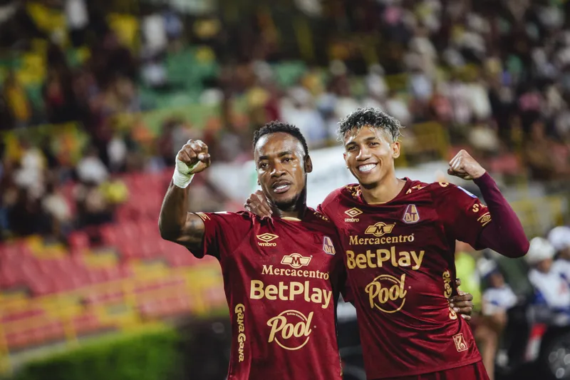 Jugadores celebrando un gol durante un partido de fútbol.