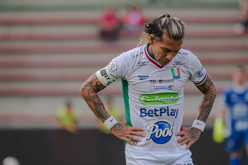Un futbolista lamentándose durante un partido.